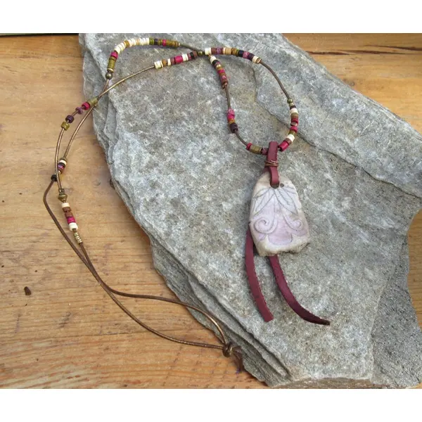 Secret poétique: un collier pour un sourire dans les yeux avec cette superbe céramique primitive