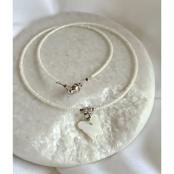 Collier ras de cou 39 cm en perles de rocaille blanches, pendentif papillon en nacre blanche, fermoir aimanté