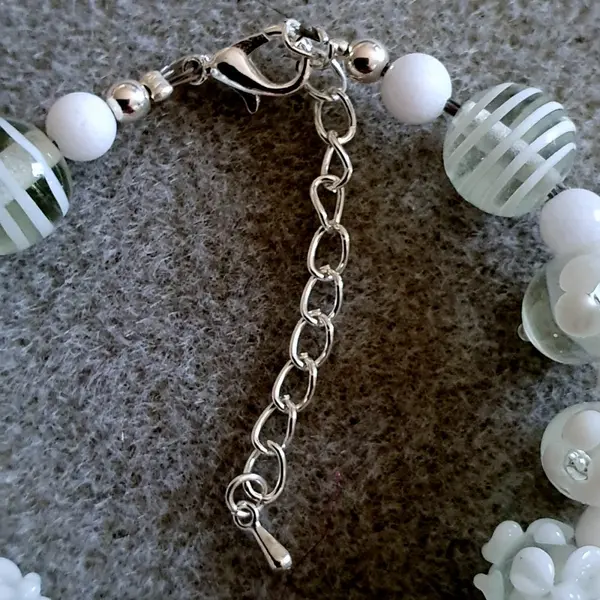 Bracelet réalisé en perles de verre fleurs blanches monté sur des éléments en argent.