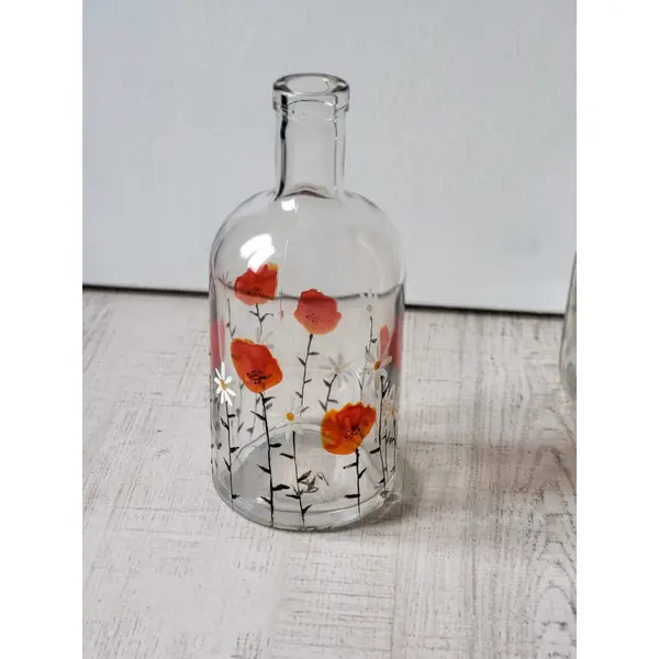 Bouteille en verre peinte d’un motif de coquelicots et pâquerettes seconde vie des objets tableau coquelicots