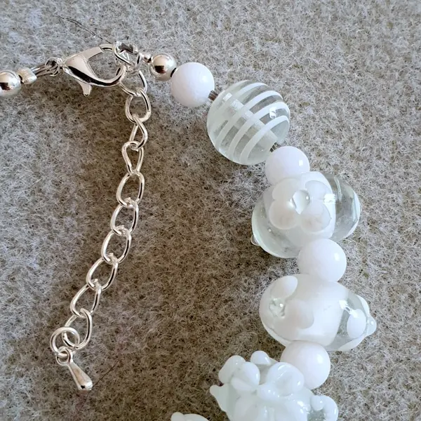 Bracelet réalisé en perles de verre fleurs blanches monté sur des éléments en argent.