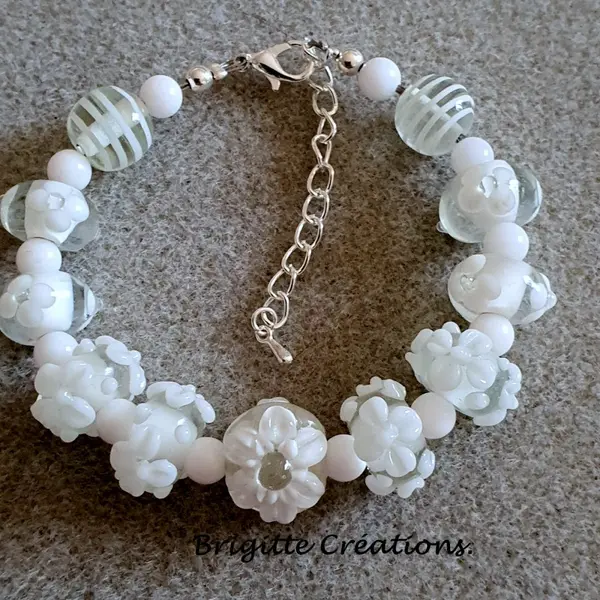 Bracelet réalisé en perles de verre fleurs blanches monté sur des éléments en argent.