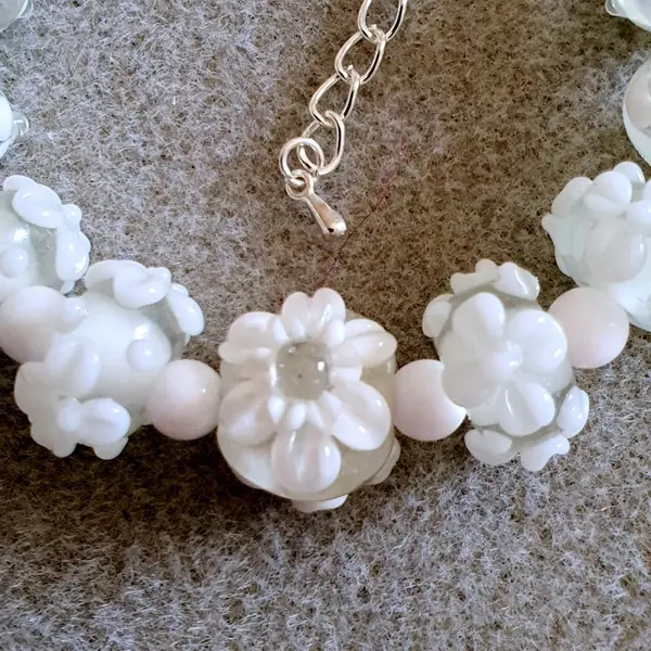 Bracelet réalisé en perles de verre fleurs blanches monté sur des éléments en argent.