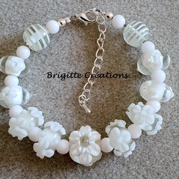 Bracelet réalisé en perles de verre fleurs blanches monté sur des éléments en argent.