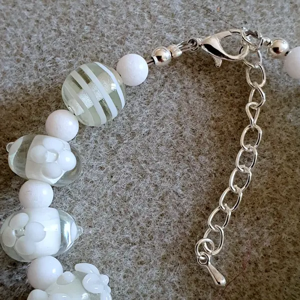 Bracelet réalisé en perles de verre fleurs blanches monté sur des éléments en argent.